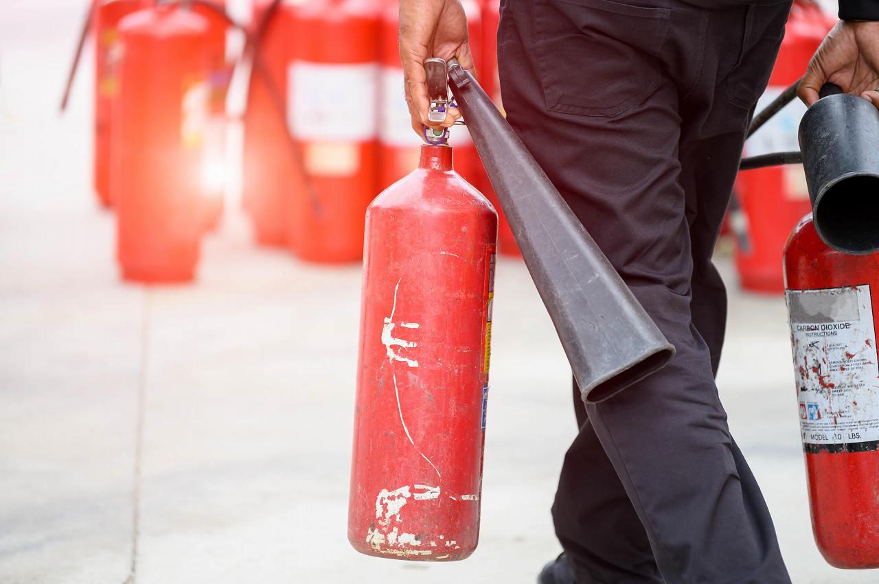 closeup-fireman-lower-body-prepare-fire-drill-by-holding-portable-fire-extinguish